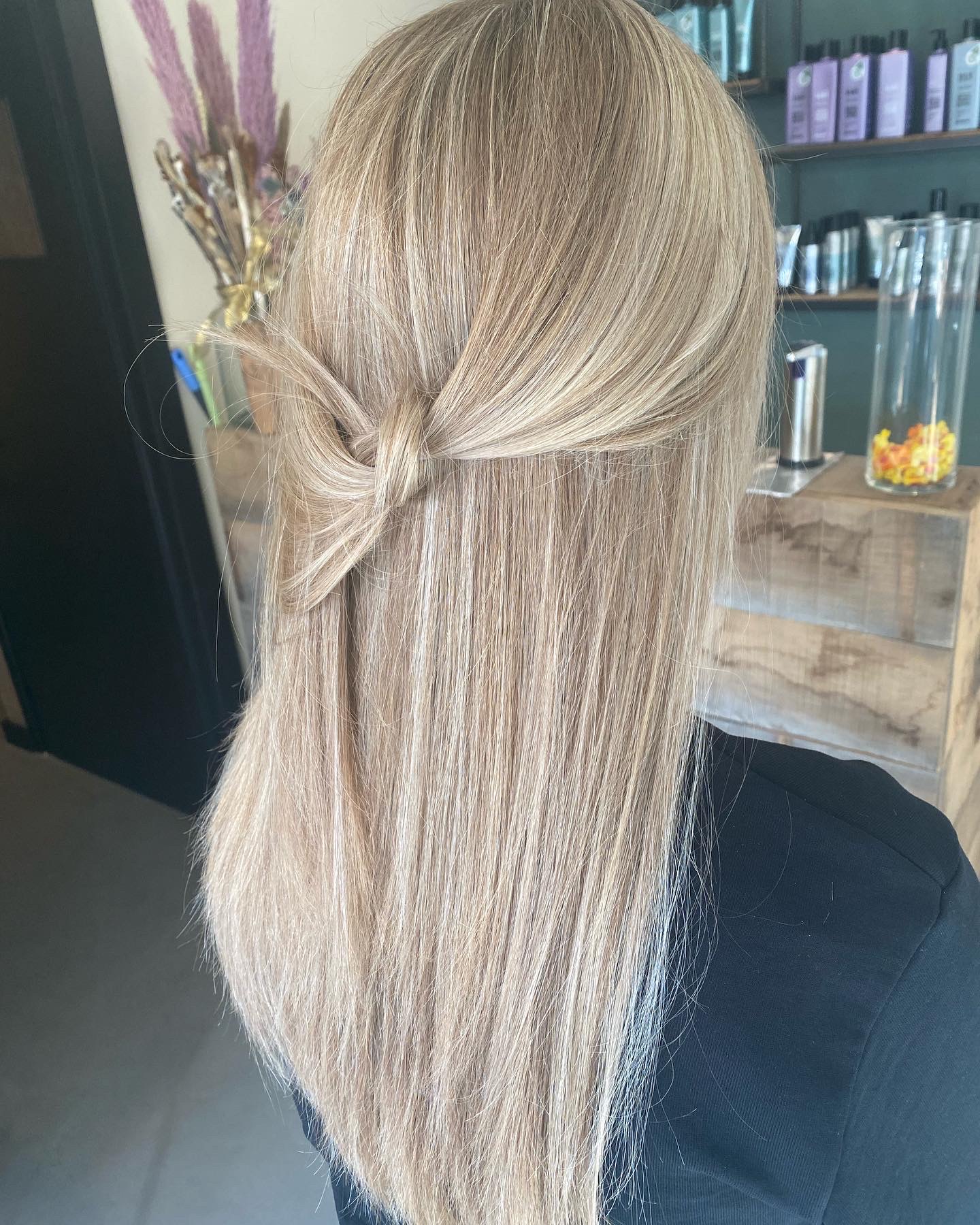 Lang asblond haar met een losse knot, half opgestoken